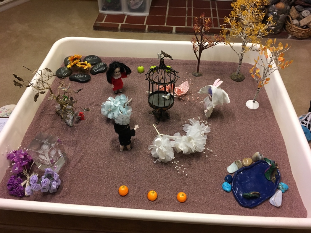 A small sand box with a group of miniature figurines